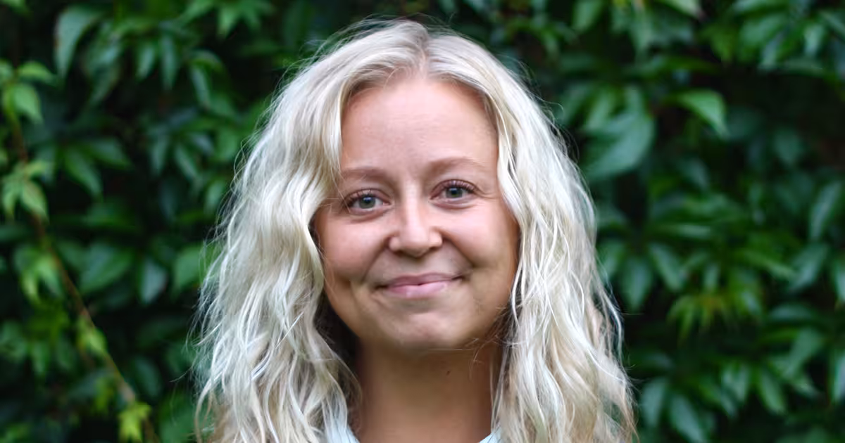 Smilende kvitte mot bakgrunn av grønne blader