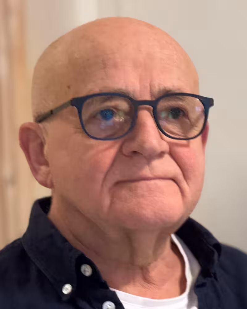 Eldre, skallet mann med seriøst ansiktsuttrykk